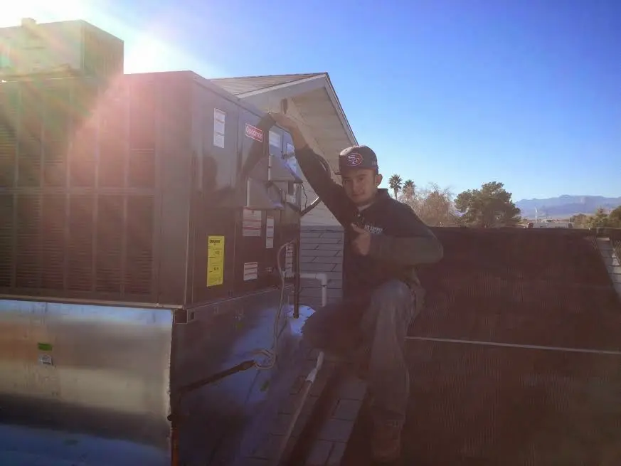 HVAC technician performing HVAC Inspection on a rooftop unit in Columbine